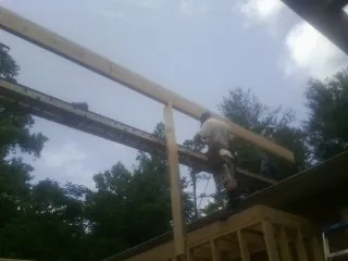 Carpenter setting a ridge beam over a new addition frame — Ice Dam Removal by Roofing Brothers in Santa Fe Springs