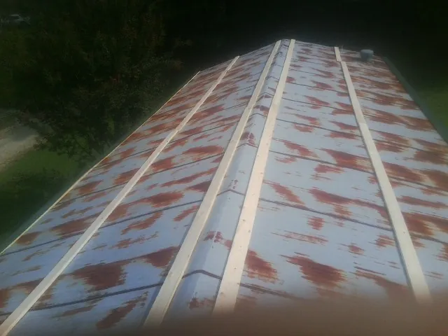Rusted metal roof panels with new wood purlins before replacement — Storm Damage Roof Repair in Santa Fe Springs by Roofing Brothers