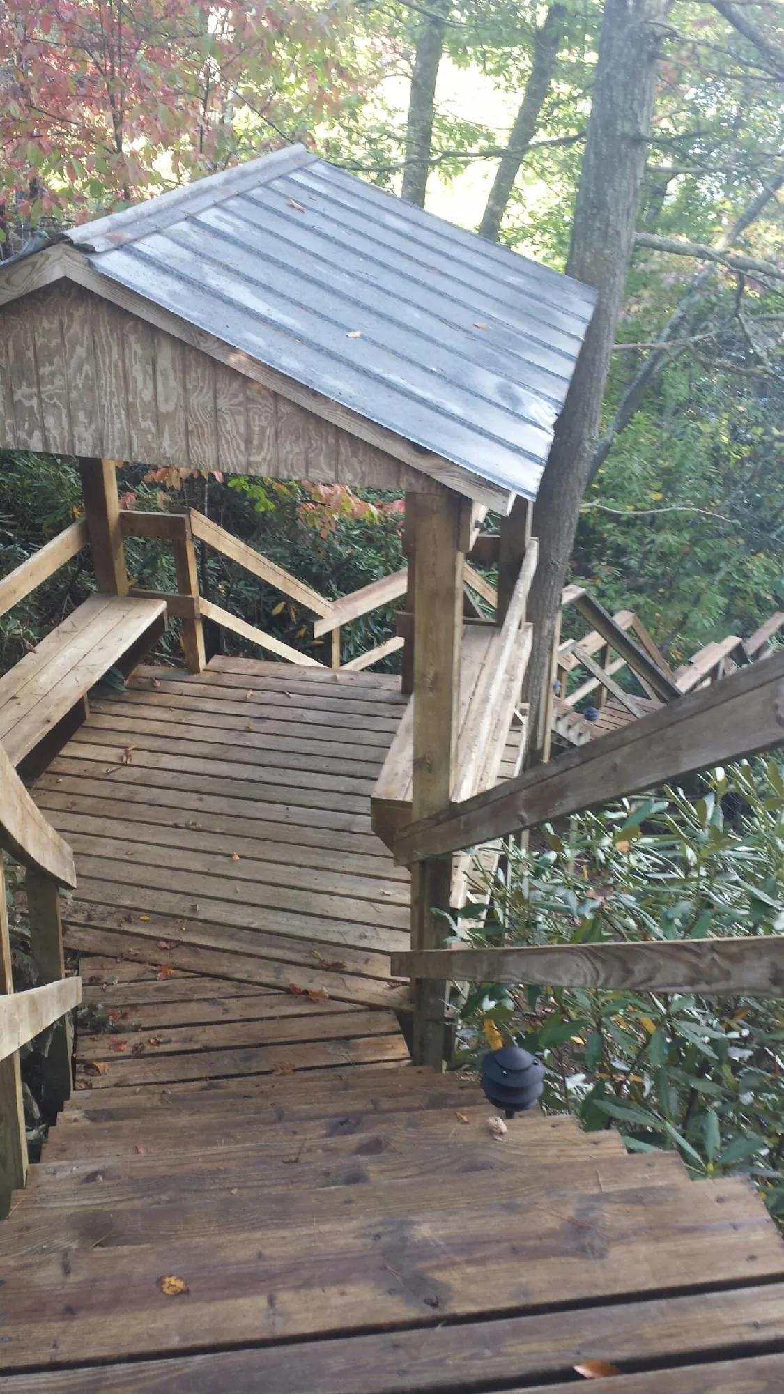 Metal roofed shelter over wooden steps on a wooded walkway — Skylight Repair & Installation work by our crew in Santa Fe Springs