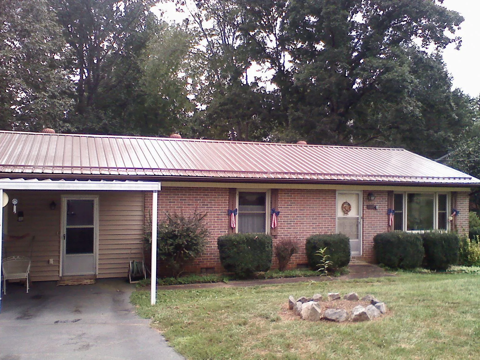 Bronze metal roof and carport on a brick ranch home — Roof Repair work by our crew in Santa Fe Springs